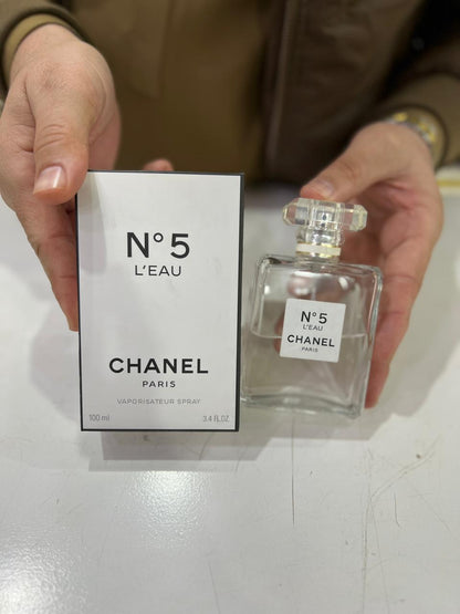 Person holding Chanel No. 5 L’Eau Eau de Toilette – Luminous & Modern Women’s Fragrance bottle and box